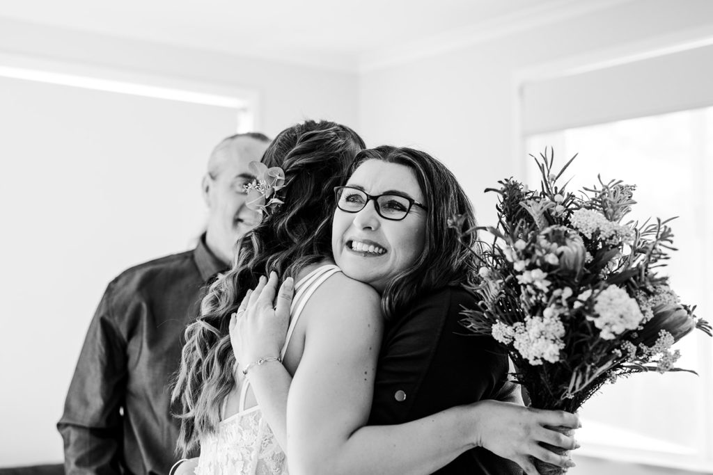 Bride hugging mum after seeing for first time in dress