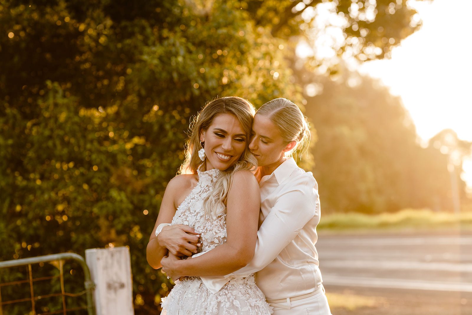 Two brides cuddling in front of sunset golden hour at Eleven Eighty Venue