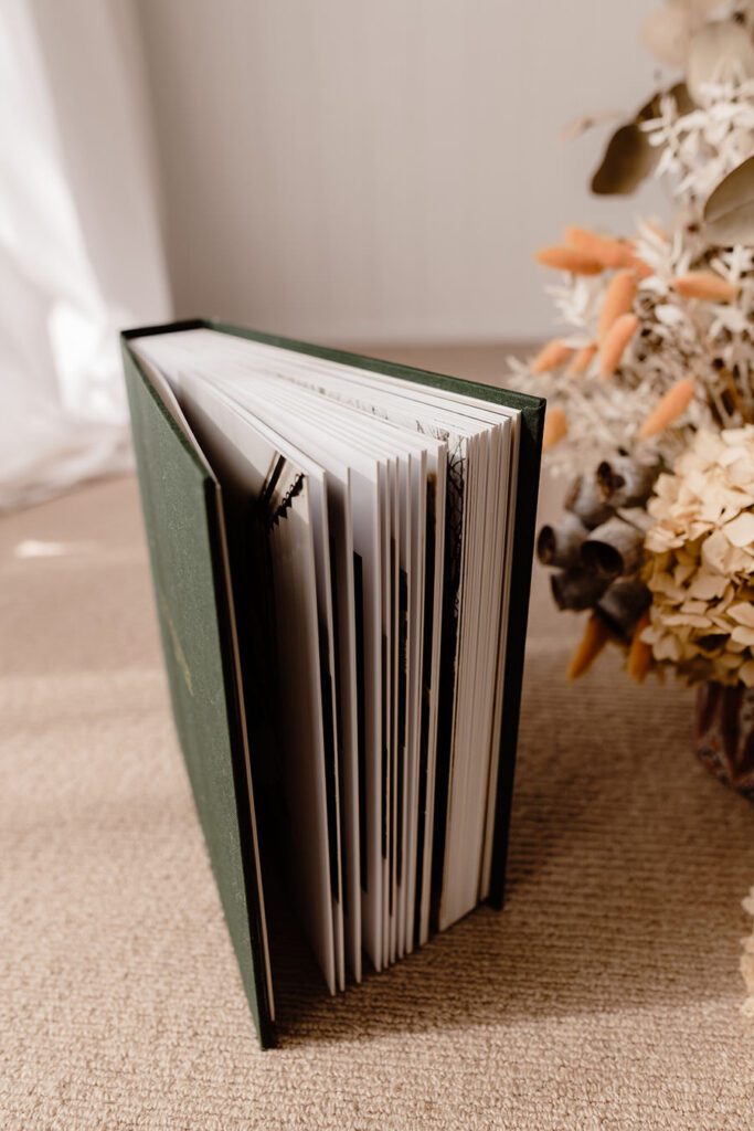 View of a green linen wedding album from the side. Viewing page thickness