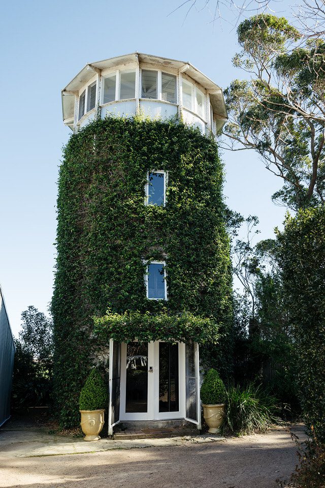 The ivy-covered grain silo accommodation at The Merribee, with French double doors at ground level and a glass-walled lookout at the top.